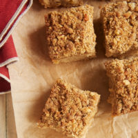 Overhead view of Caramel Apple Crumb Cake squares on brown parchment paper