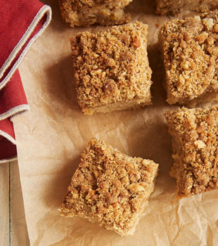 Overhead view of Caramel Apple Crumb Cake squares on brown parchment paper