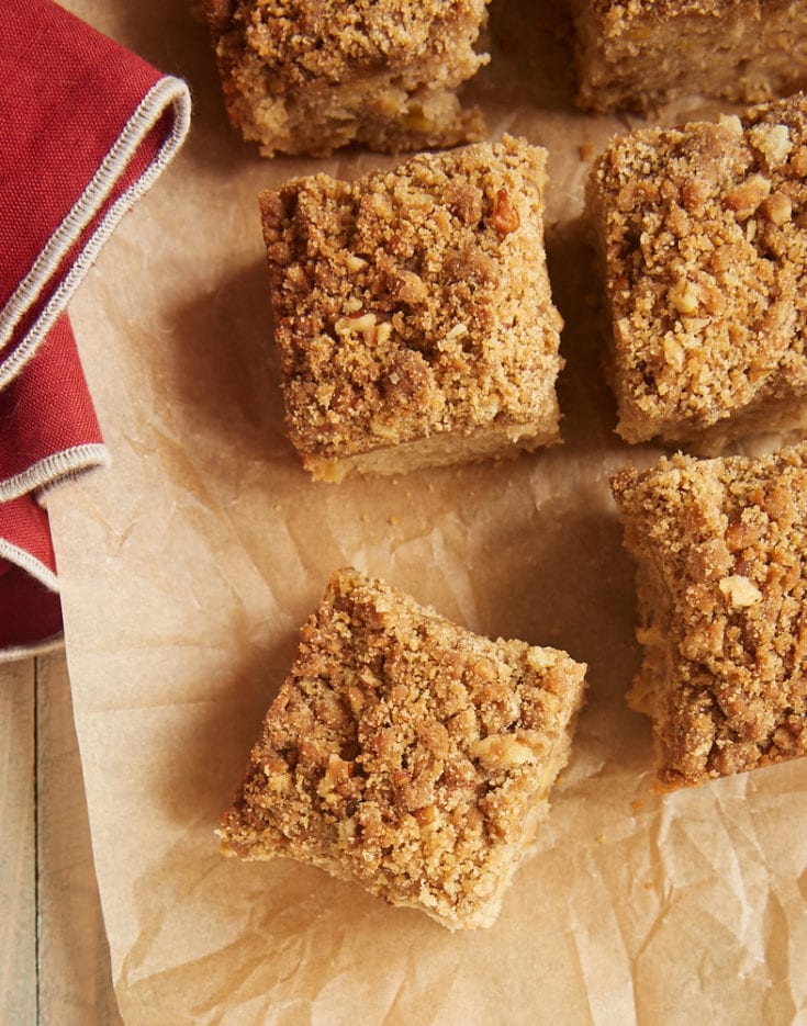 Overhead view of Caramel Apple Crumb Cake squares on brown parchment paper
