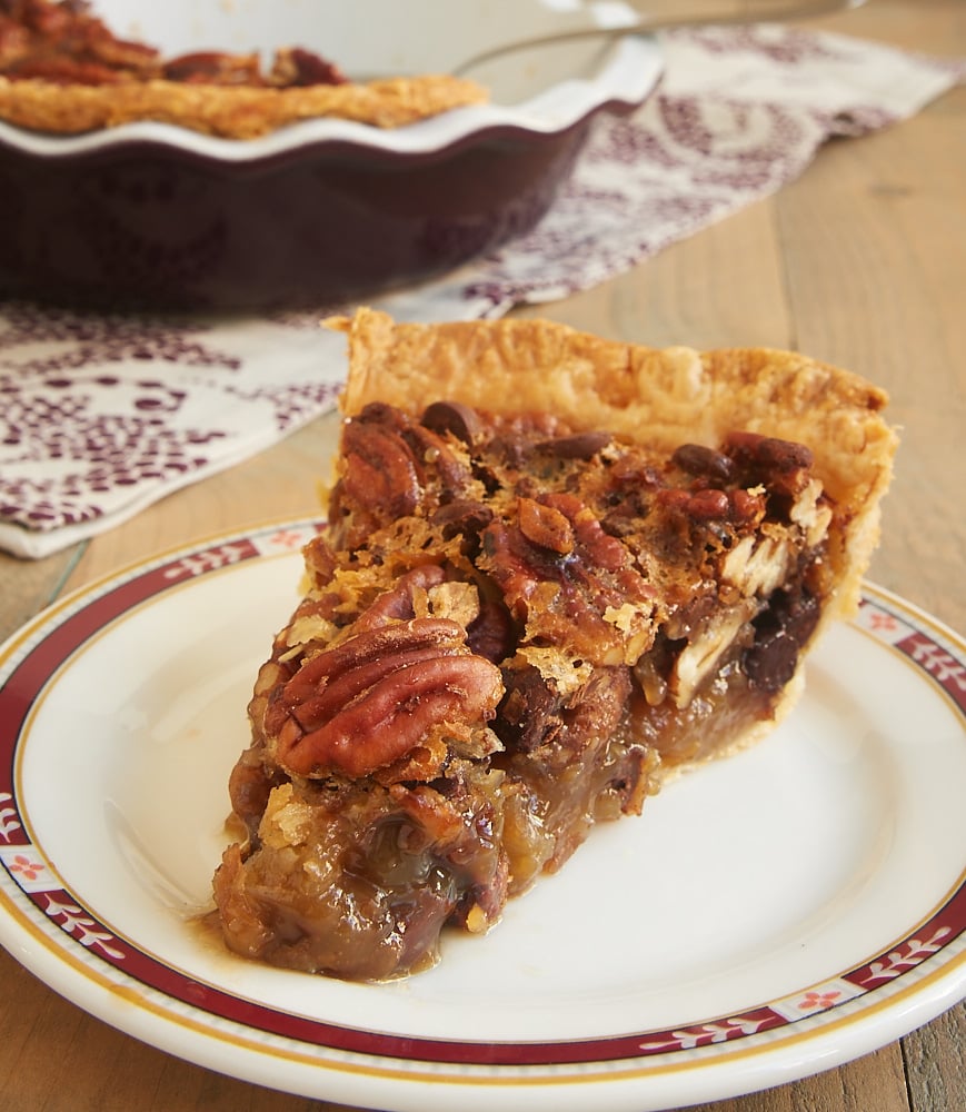 A slice of chocolate pecan pie on a plate.