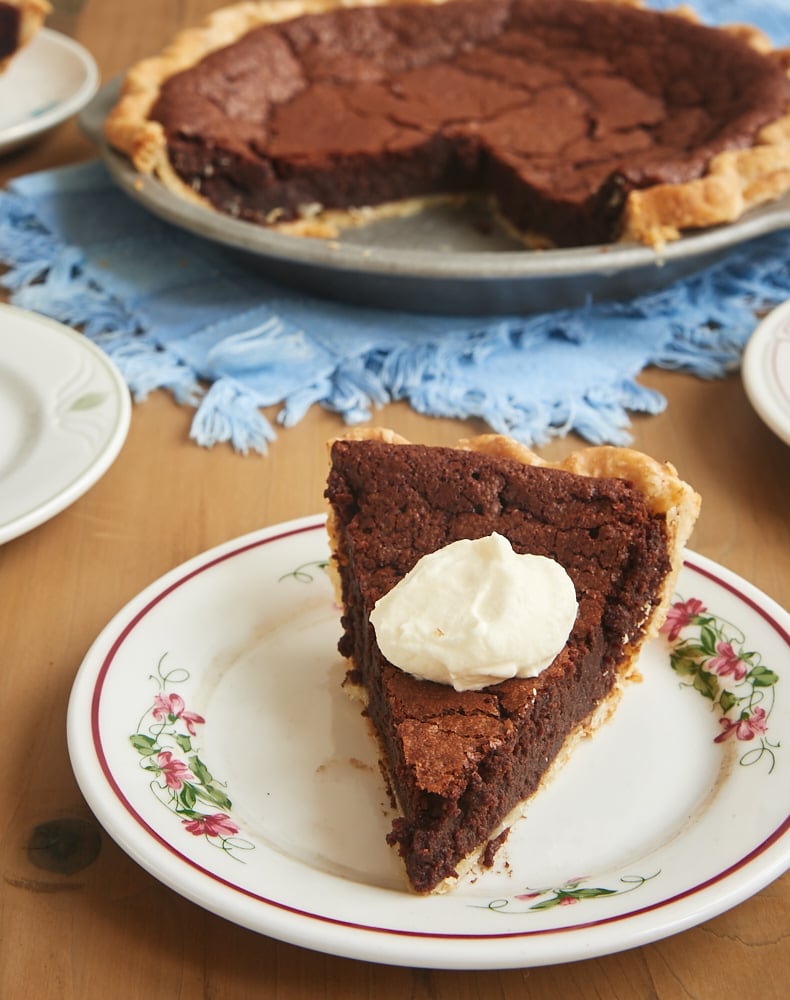 Slice of chocolate chess pie topped with whipped cream