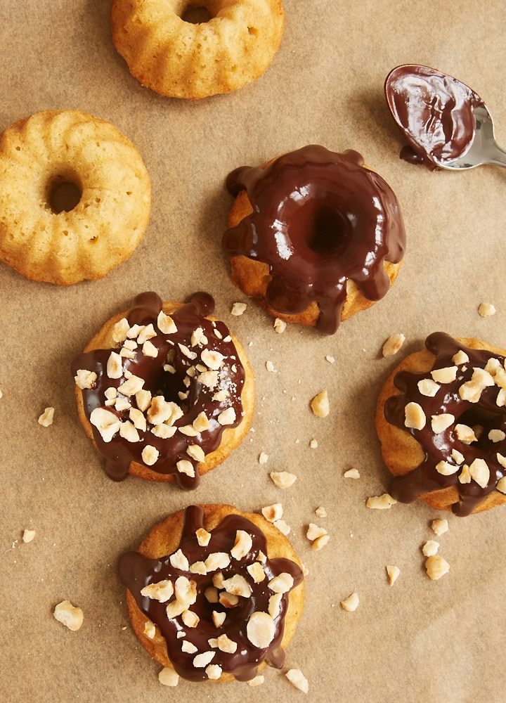 Brown Butter Hazelnut Bundt Cakes with ganache and hazelnuts being added