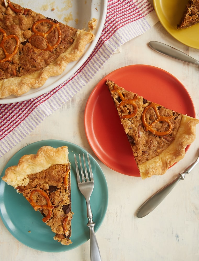 slices of Monster Cookie Pie on orange, green, and yellow plates