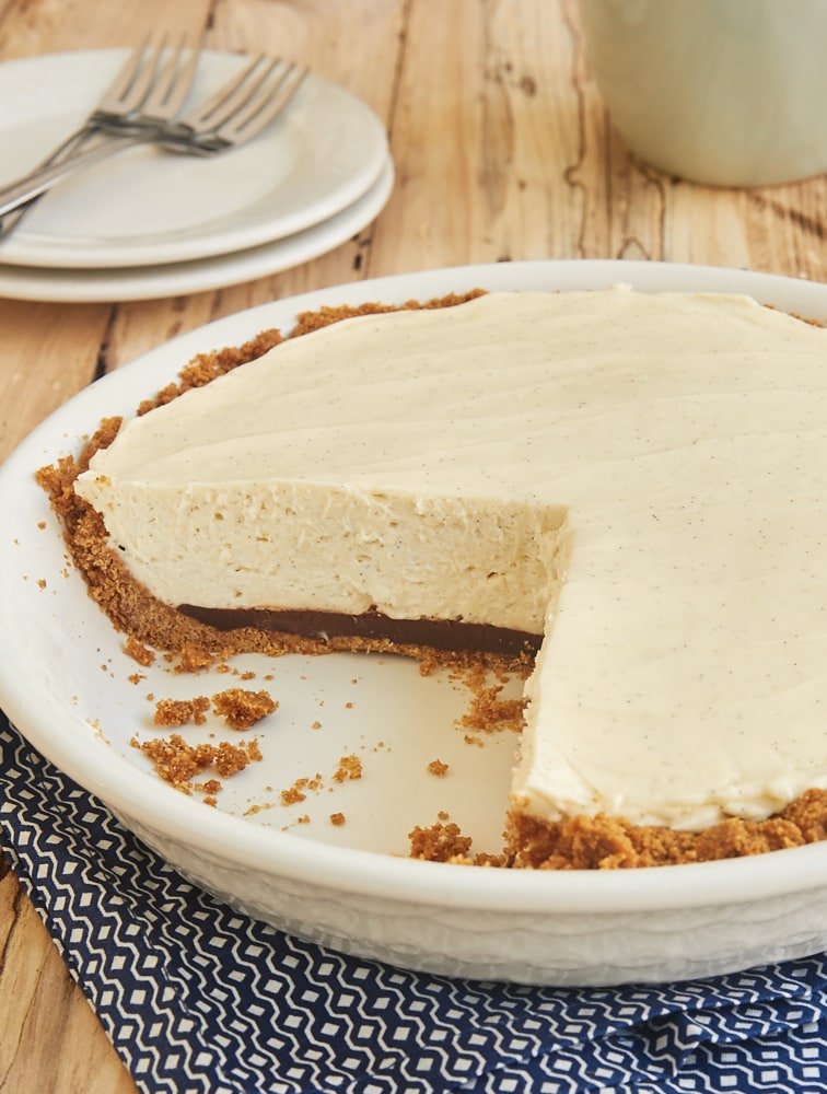 No-Bake Black Bottom Vanilla Bean Cheesecake in a white pie plate with two slices removed