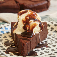 Slice of Easy Chocolate Torte topped with ice cream and chocolate sauce
