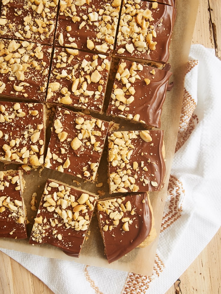 Chocolate peanut butter shortbread bars sliced on parchment paper.