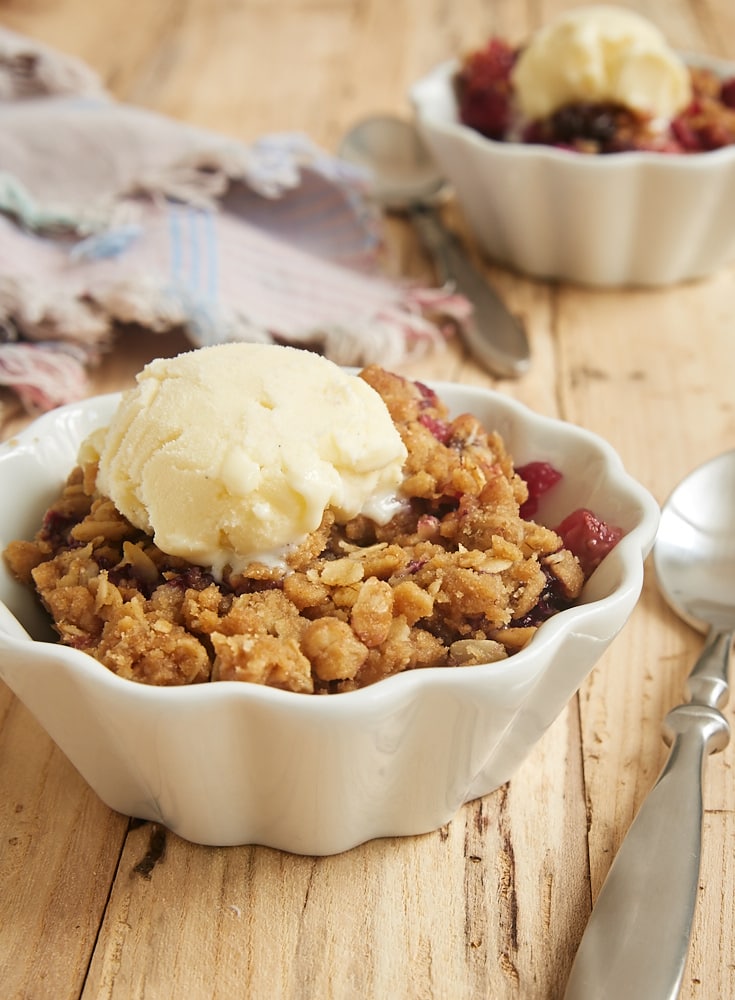 Skillet Berry Crumble served with ice cream in a white fluted bowl