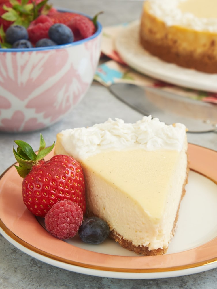 slice of Vanilla Bean Cheesecake served with fresh berries