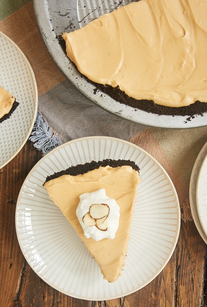 overhead view of a slice of Dulce de Leche Icebox Pie on a white and beige striped plate