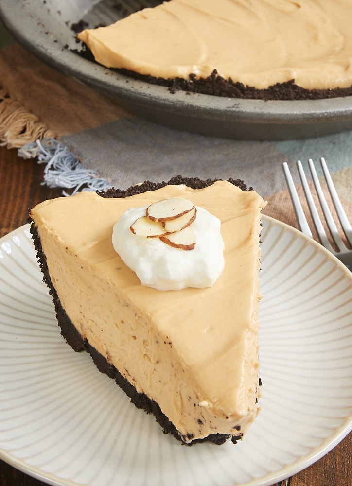 slice of Dulce de Leche Icebox Pie on a white and beige striped plate