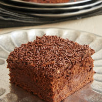 A side view of a brownie with a layer of chocolate cream cheese in the middle.