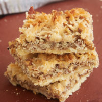 Stack of Coconut Pecan Shortbread Squares on a cutting board.