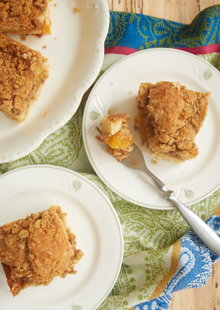 overhead shot of slices of Peach Cobbler Coffee Cake on green-rimmed white plates