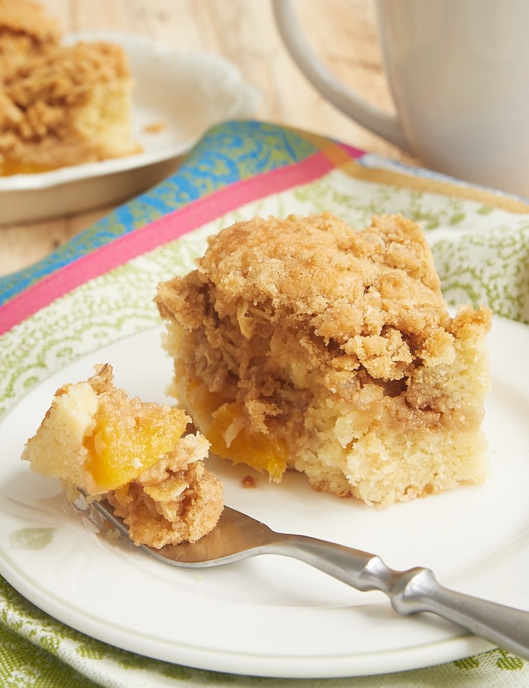 slice of Peach Cobbler Coffee Cake on a green-rimmed white plate