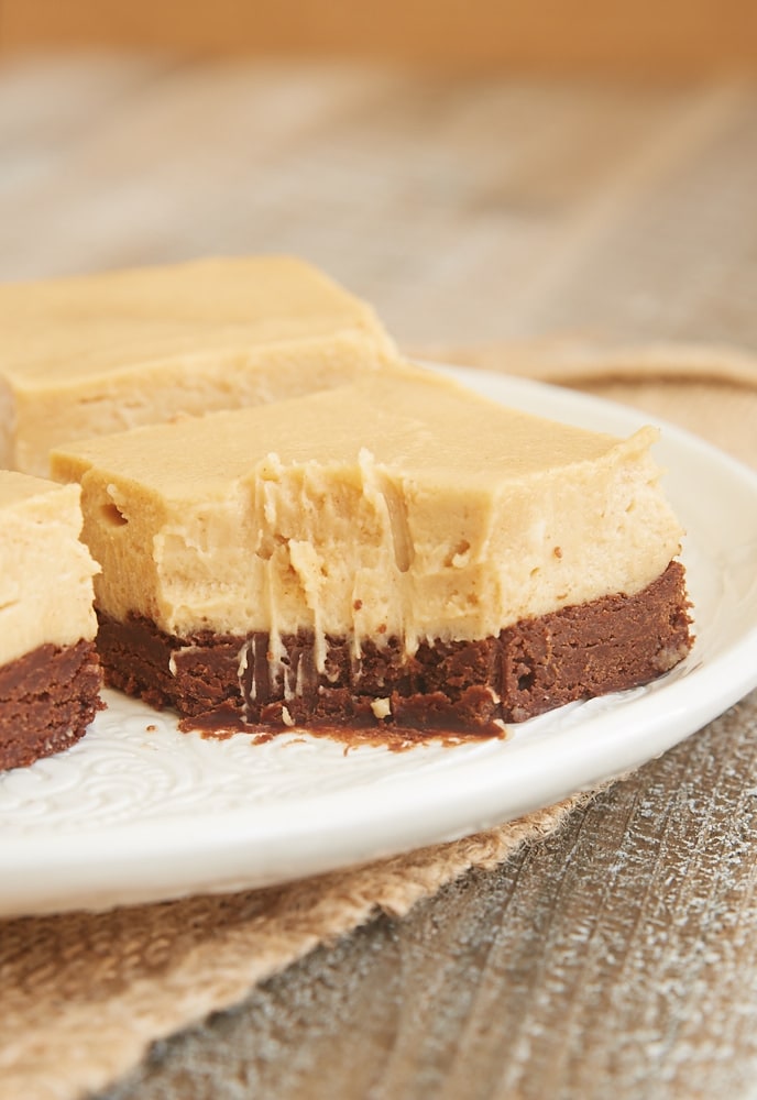 a slice of Brownie Bottom Peanut Butter Pie Bars with a bite missing