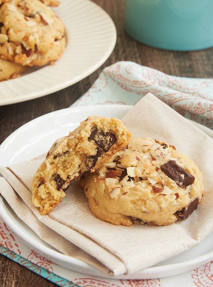 one and a half Coconut Almond Chocolate Chip Cookies on a beige napkin on a white plate