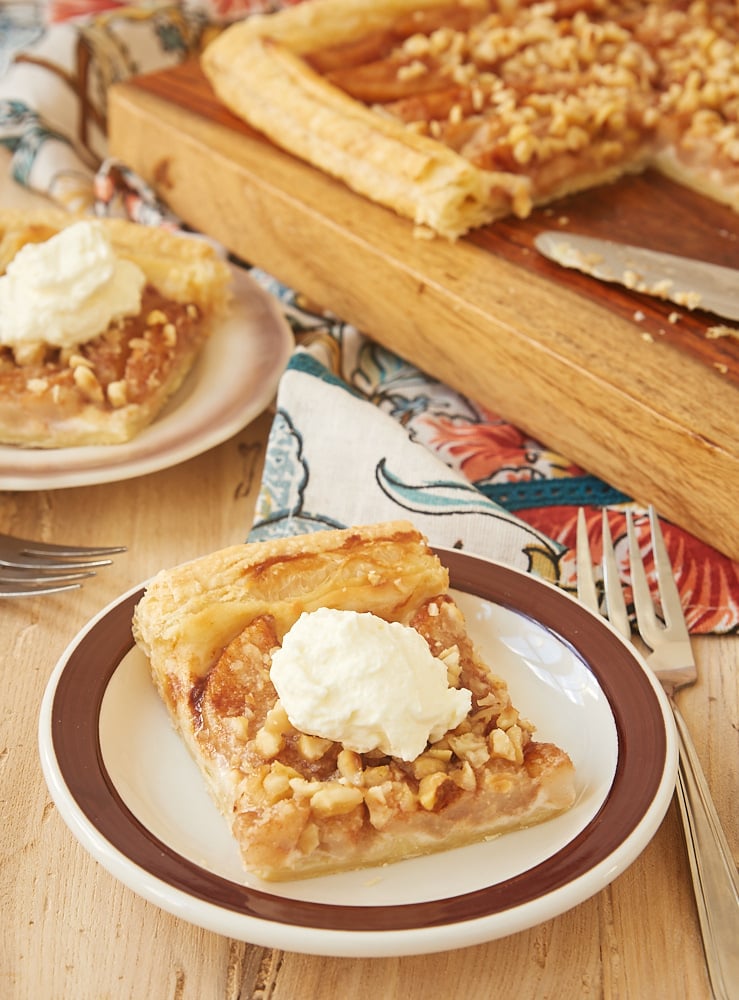 slices of Cream Cheese-Filled Pear Tart on brown-rimmed white plates