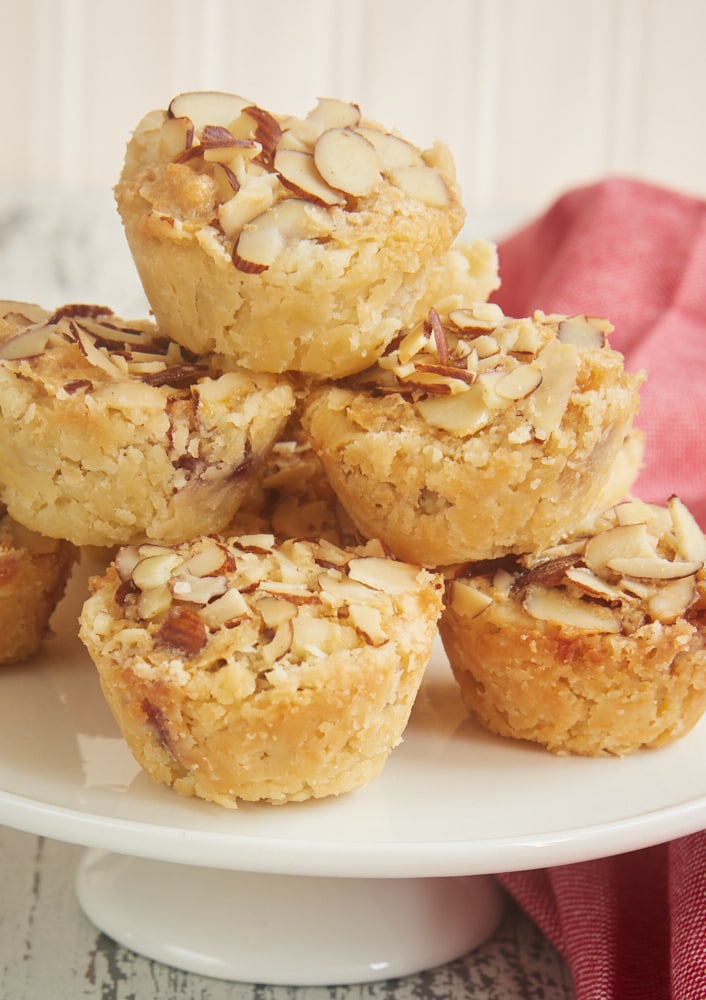 Raspberry Almond Tarts stacked on a small white pedestal tray