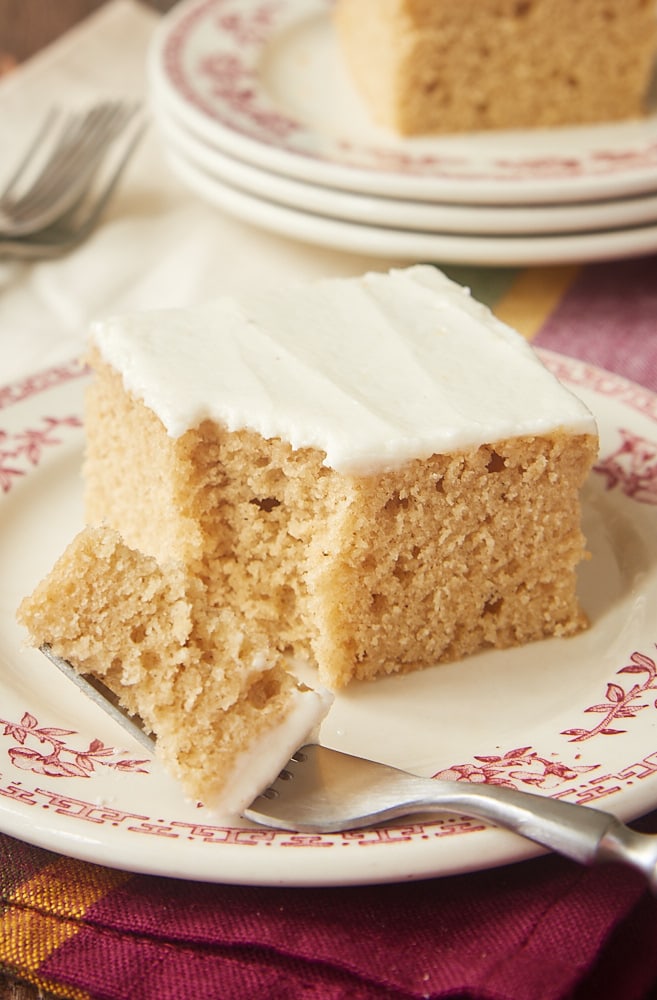 slice of Spice Cake with Brown Butter Frosting on a red-rimmed white plate