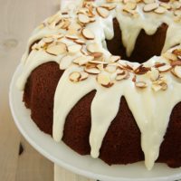 Blueberry Jam Cake topped with a cream cheese glaze and almonds - Bake or Break