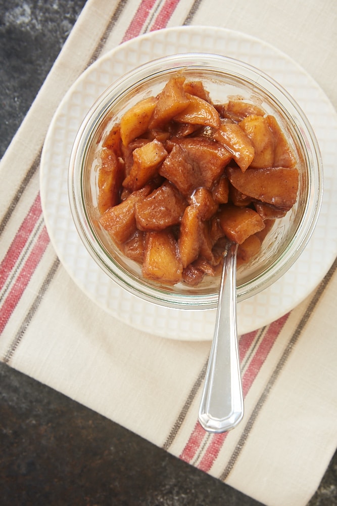 overhead view of Spiced Apple Compote in a glass container sitting on a beige and white plate