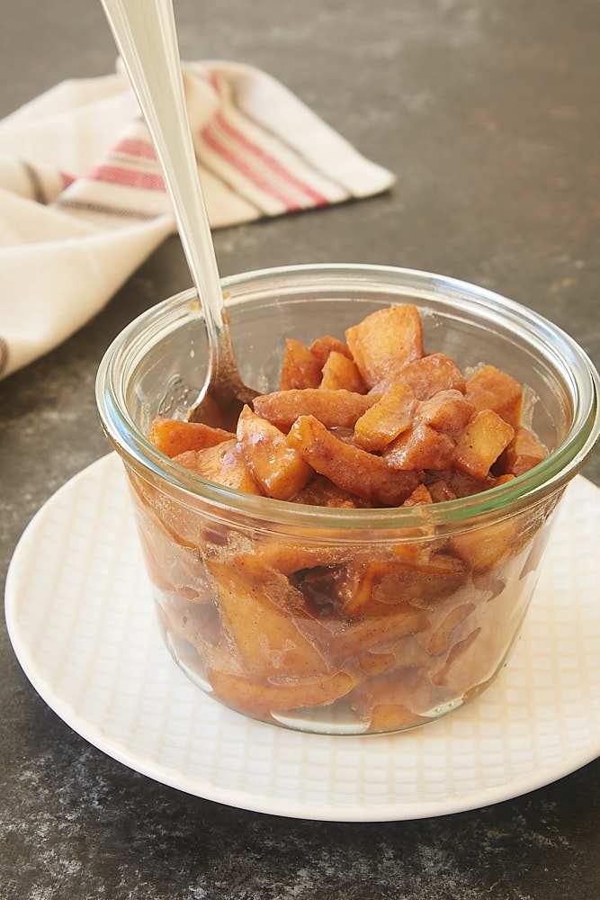 Spiced Apple Compote in a glass container with a spoon