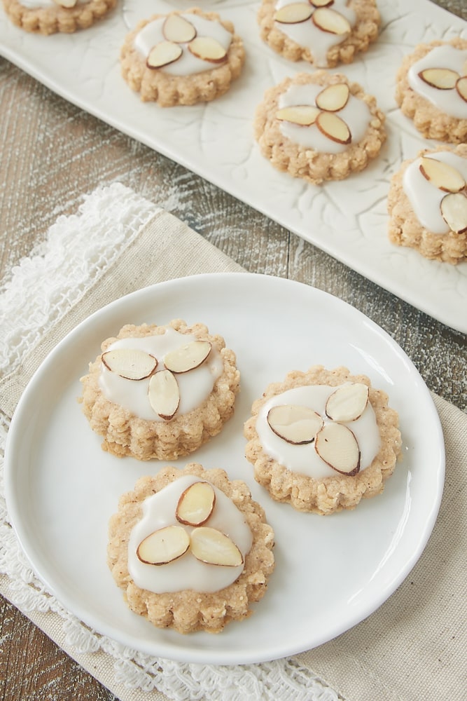 Almond spice cookies topped with glaze on a plate.