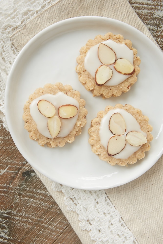 Almond spice cookies topped with a sweet glaze and sliced almonds.