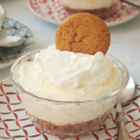 No-Bake Lemon Cheesecakes topped with sweetened whipped cream and gingersnaps