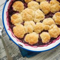 Blueberry Cobbler with Ginger Biscuits in a blue-rimmed white bowl