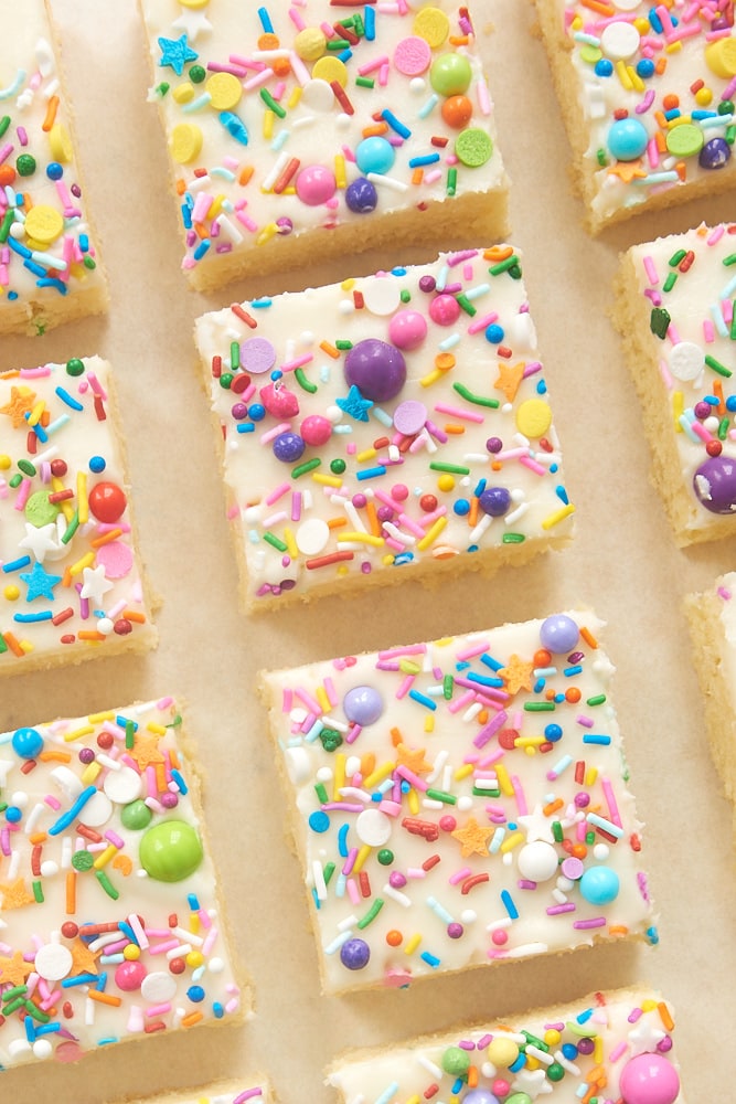 Frosted sugar cookie bars topped with colorful sprinkles.