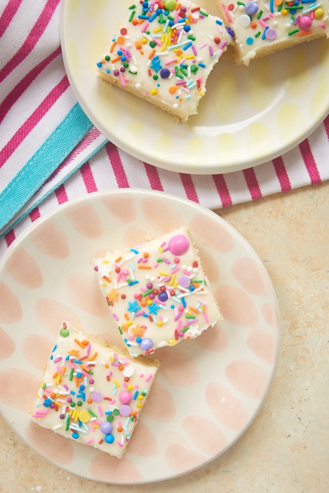 Frosted Sugar Cookie Bars served on colorful plates