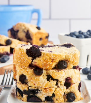 Blueberry loaf slices stacked on a plate.