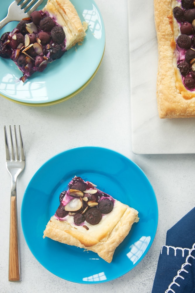 slices of Blueberry Cream Cheese Tart on blue plates