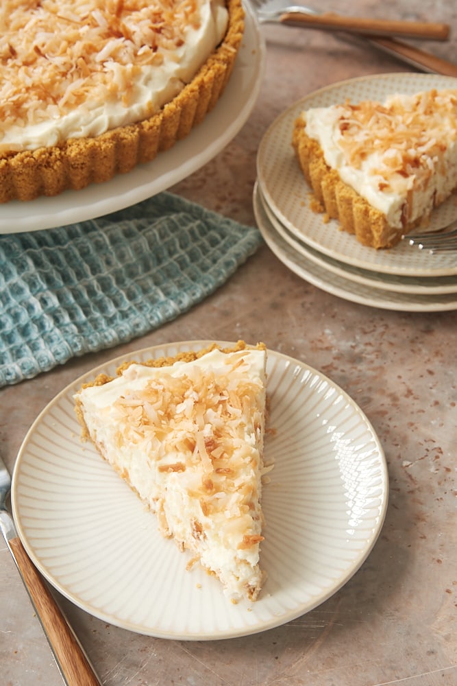 slices of No-Bake Coconut Cheesecake on white and beige plates