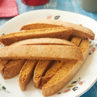 Vanilla Biscotti stacked on a white plate with a floral rim