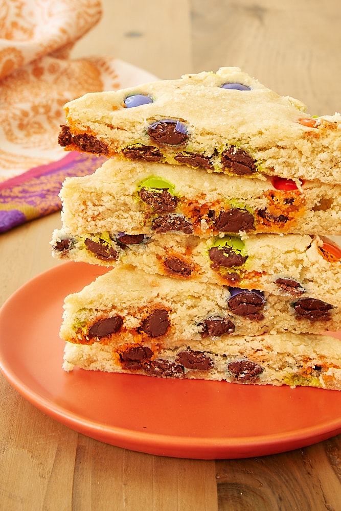 M&M sugar cookie bars on an orange plate.