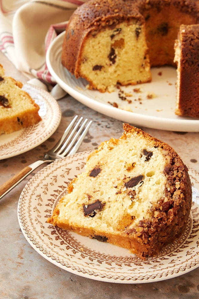 Slice of Chocolate Chunk Pecan Crunch Bundt Cake on a floral plate.