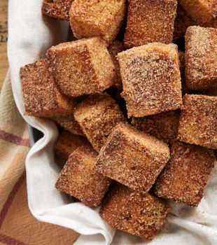 Cinnamon Sugar Pound Cake Bites piled in a towel-lined basket