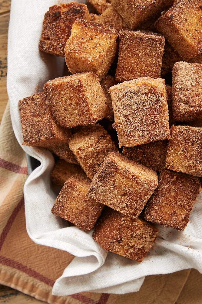 Cinnamon Sugar Pound Cake Bites piled in a towel-lined basket