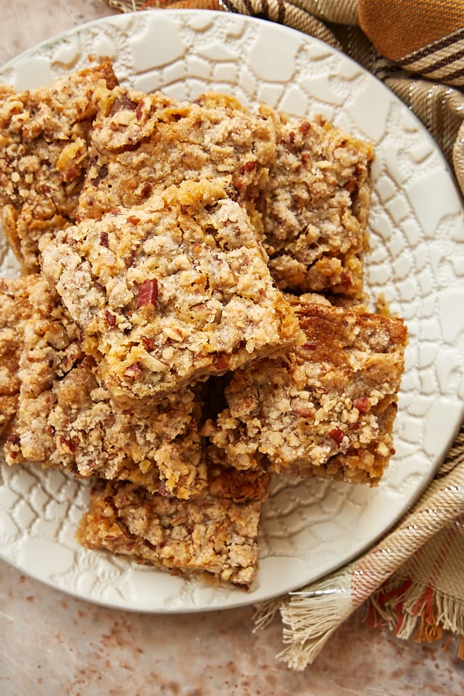 stack of Chewy Pecan Pie Bars on an off-white plate