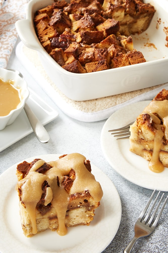 Cookie Butter Pound Cake Bread Pudding in a white ceramic baker with servings on white plates