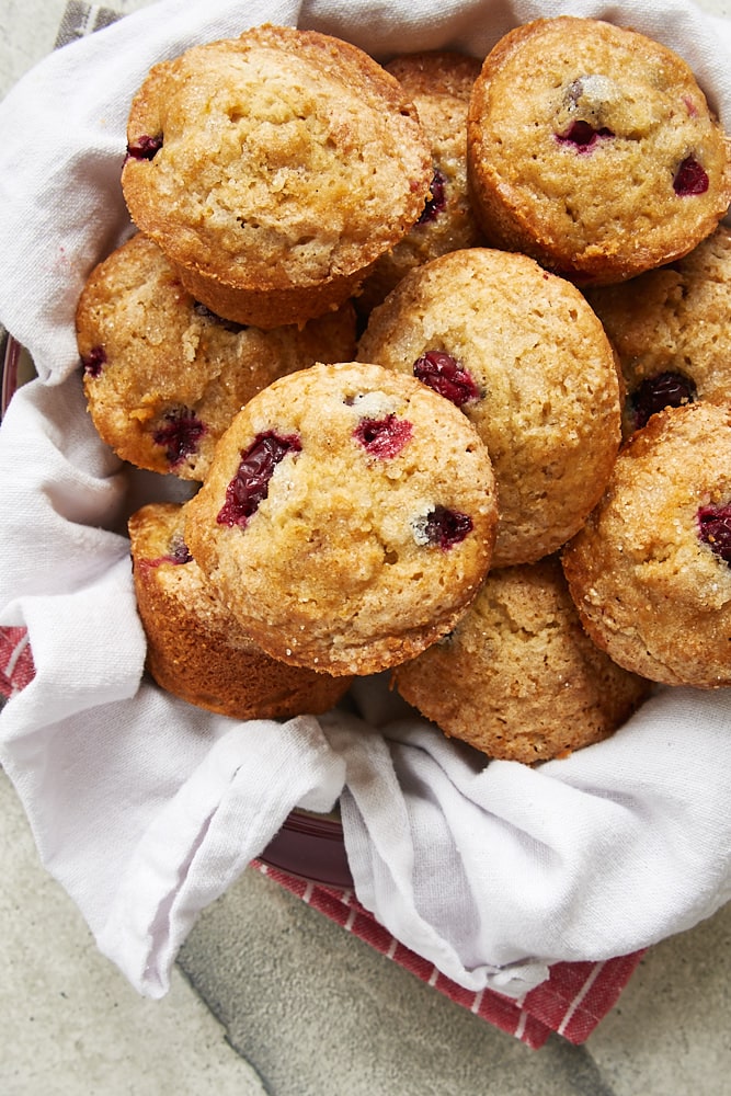 Cranberry Orange Muffins in a red dish lined with a white linen napkin