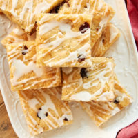 Cranberry White Chocolate Blondies stacked on a white tray