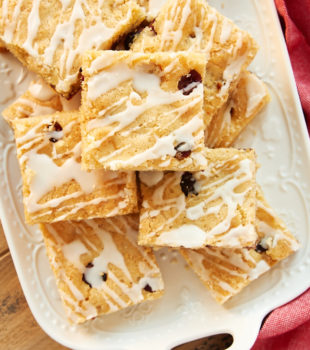 Cranberry White Chocolate Blondies stacked on a white tray