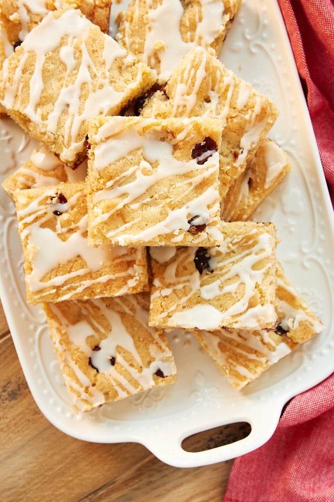 Cranberry White Chocolate Blondies stacked on a white tray