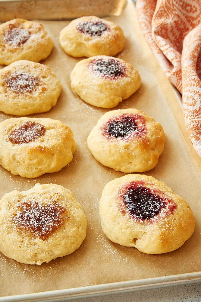Fruit-filled Kolaches on a baking sheet, dusted with powdered sugar