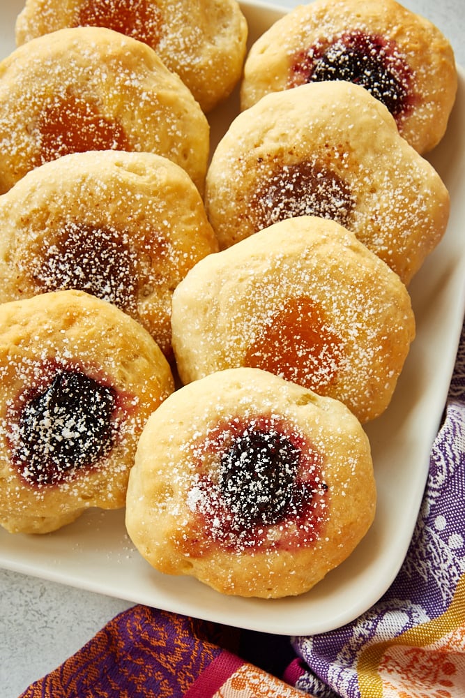 Kolaches dusted with powdered sugar on a white serving tray