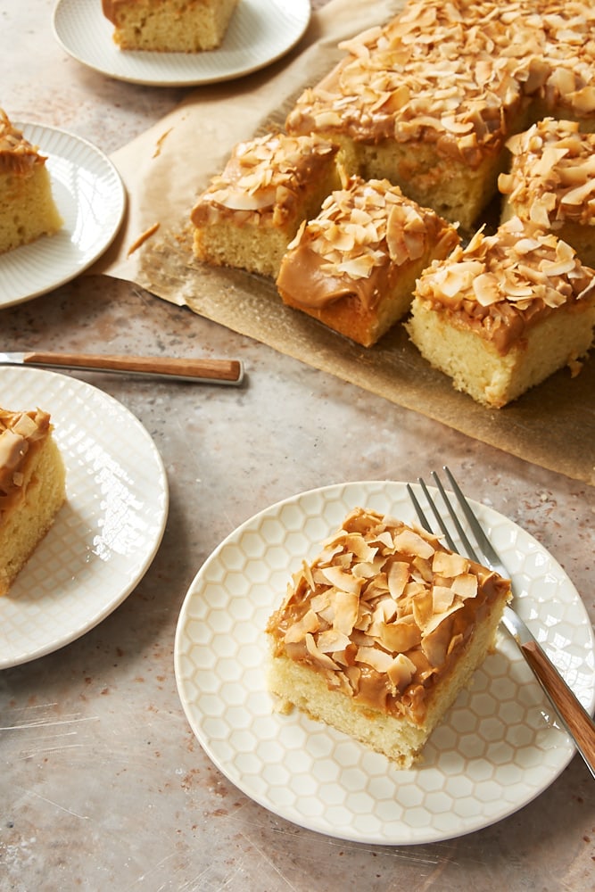 slice of Coconut Cake with Dulce de Leche Frosting on a white and beige plate