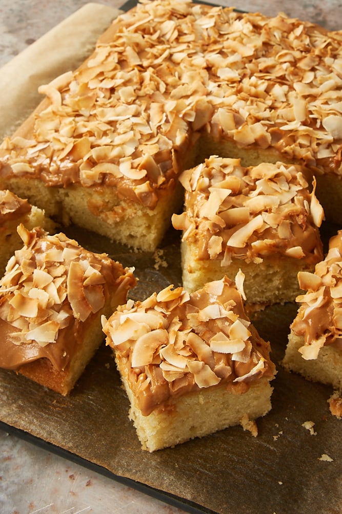 Coconut Cake with Dulce de Leche Frosting on a parchment covered serving board